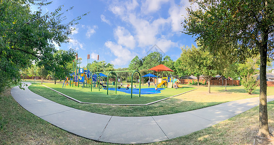 全景全景 周围的游乐场 有太阳遮阳帆 在德克萨斯州美州Mound的花草蓝色闲暇孩子玩具人行道遮阳棚民众途径运动梯子图片