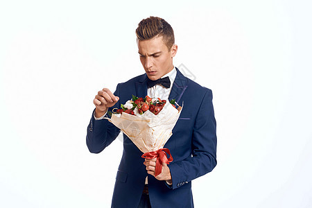 一个穿着经典西装的优雅男子 领领结领带 手里握着一束花束展示男人周年婚礼丈夫花朵生日成人商务纪念日图片