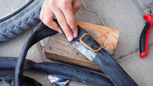 做自行车轮胎修理 一个人正在修复一个穿刺自行车内管运动工具爆胎白色管子橡皮维修刺破行车空气图片