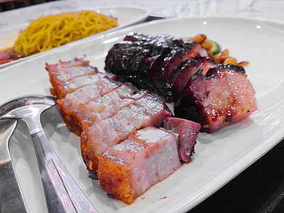 白盘上中国式的烧烤猪肉和BBQ猪肉图片