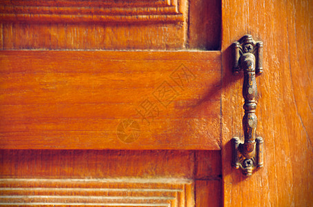 古老的门把手 在旧的木制门背景金属安全出口房子阴影建筑阳光入口建筑学灯光背景图片