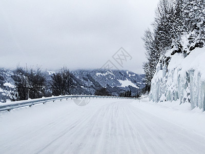 在挪威的雪路和风景中行驶旅行运输暴风雪瀑布交通森林乡村小路国家天气图片