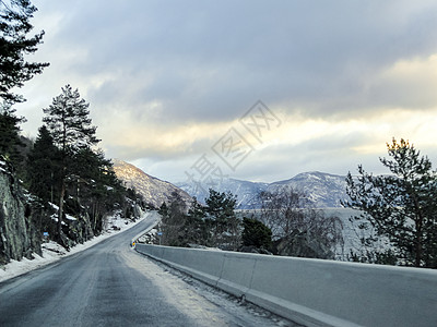 日出时在挪威黑冰河边的峡湾驾驶黑冰景观蓝色雪景旅行太阳光线爬坡山脉速度金子图片