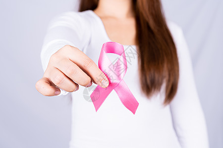 女性胸前的乳癌认知带 灰色背景 医疗 保健 宣传概念 在卫生方面治疗机构幸存者帮助外科治愈风险药品癌症女孩图片
