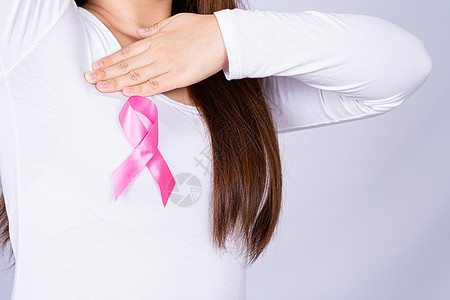 女性胸部的乳腺癌意识丝带和灰色背景下的自我检查 广告概念的医疗 保健化疗活动帮助生活治疗检查考试疾病外科癌症图片