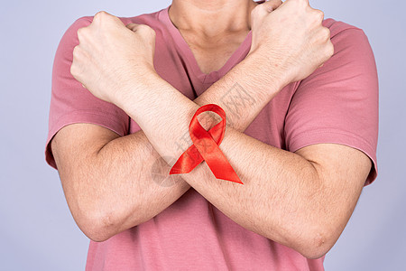 男人手臂上的红色艾滋病意识丝带 举起手在灰色背景下与他们作斗争 世界艾滋病日 医疗保健和医疗概念疾病预防丝绸团结癌症机构性别插图图片