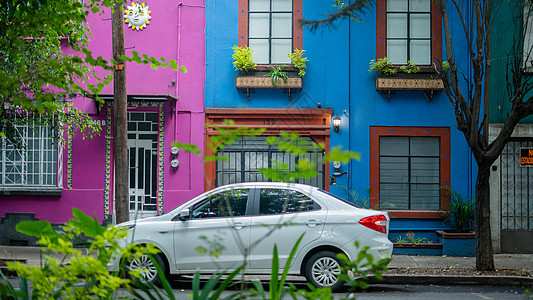 白色汽车停泊在两座多彩房子外 来自科约阿坎邻邦背景图片