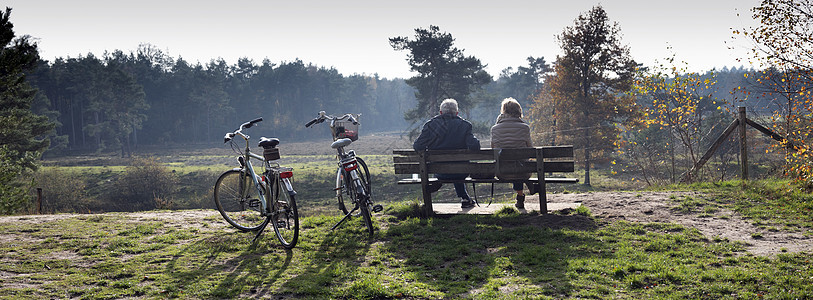 一对夫妇坐在长凳上休息 从自行车旅行 秋季森林秋天 在霍兰德泽伊斯特附近闲暇男人橙子夫妻冒险假期农村娱乐踪迹家庭图片