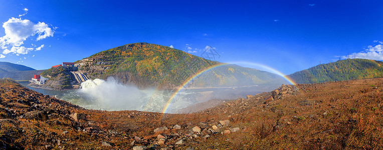 全尺寸美丽明亮的彩虹以秋天的山丘和一条小溪为背景 溢洪道水电彩虹环境折射光谱太阳蓝色气象日光土地棱镜幸福背景图片