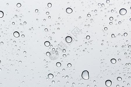 玻璃镜背景上的水滴黑色雨滴窗户灰色交通天空白色飞沫玻璃驾驶图片