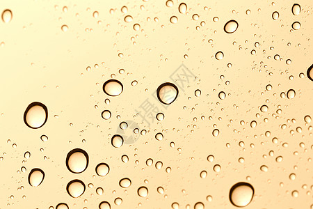 玻璃镜背景上的金水滴灰色黄色日落黑色飞沫下雨金子交通玻璃窗户图片