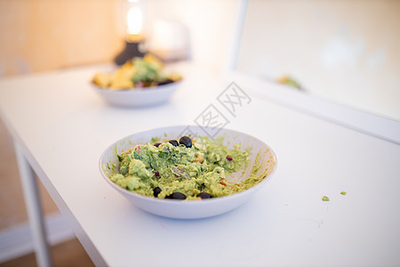 白桌上加橄榄的瓜卡莫油酱碗小吃午餐筹码美食食物鳄梨盘子镜子蔬菜草本植物图片