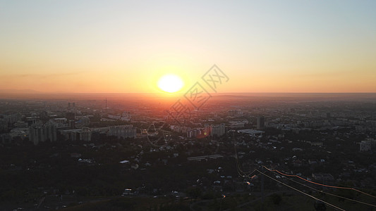 红色日落在阿拉木图市上空城市景观地标商业天际射线全景树木天线建筑学图片