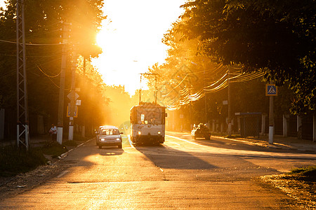 俄罗斯图拉 — 2013 年 6 月 6 日 红绿灯上的汽车和电车在金色太阳背光下停止 空气发光明亮图片