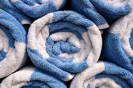 卷起蓝色和白色的温泉或泳池毛巾图片