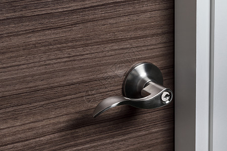 洗手液不锈钢铁门把手或木制门上的钥匙孔灯光板条锁孔房子房间入口杠杆金属安全隐私背景