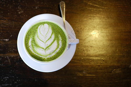 热辣的日本火柴 绿色茶加拿铁艺术饮料食物咖啡牛奶奶油桌子咖啡店抹茶杯子图片