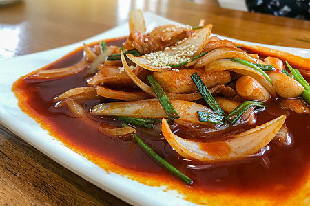 美味的韩国辣肉特okbokki 在木本背景上的辣辣特okbokki图像小吃盘子年糕筷子烹饪美食食物食品文化午餐图片