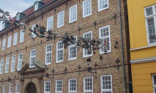 在德国最北边的小镇 名叫弗伦斯堡的老房子之间挂着鞋子吸引力旅行衣服建筑阳光金属蓝色运动鞋建筑学艺术品图片