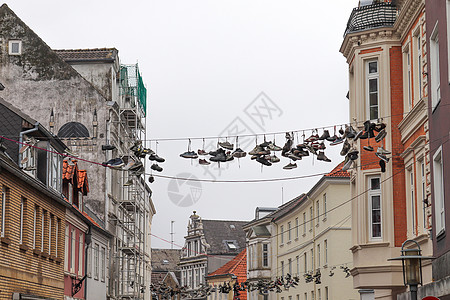 在德国最北边的小镇 名叫弗伦斯堡的老房子之间挂着鞋子旅行建筑物鞋类街道生活建筑学运动鞋细节衣服艺术品图片
