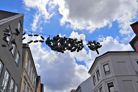 在德国最北边的小镇 名叫弗伦斯堡的老房子之间挂着鞋子生活蓝色蓝天金属乐趣旅游艺术品细节旅行天空图片