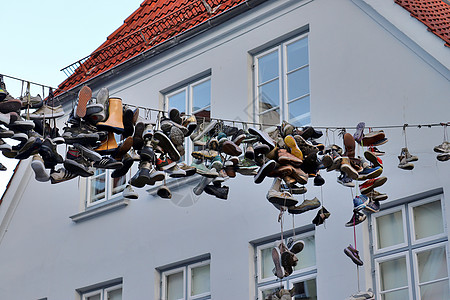 在德国最北边的小镇 名叫弗伦斯堡的老房子之间挂着鞋子建筑物蓝色运动鞋街道旅行细节生活蓝天艺术品天空图片
