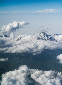 高山峰在云层 顶端的视野 从飞机上地平线顶峰天空白色蓝色航班环境岩石旅行场景图片