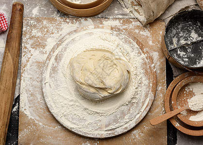 圆木板上有白麦面粉的一整块圆形面粉面包师营养桌子美食糕点食物面包花冠粮食厨房图片