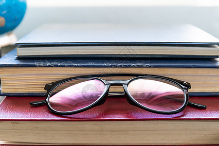 阅读眼镜贴在硬皮书上光学学习科学学生桌子大学静物商业精装教育图片