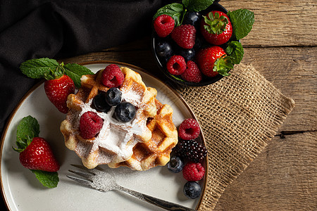比利时华夫饼和夏季水果 在黑色木制背景的盘子上深色胡扯蛋糕覆盆子糖浆早餐美食面包食物糕点图片