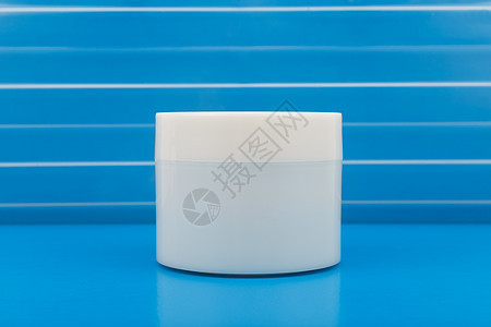 在蓝桌蓝色背景下 贴近无名白花霜 凉粉 遮罩或其他美容产品罐图片