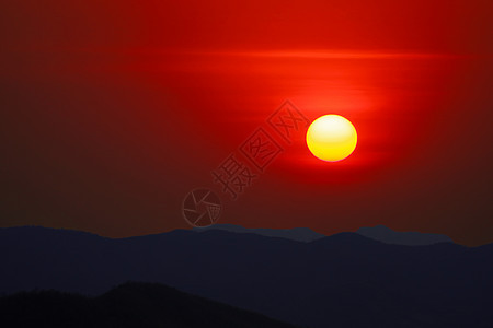 黄昏的夜空日落 在阴暗的山丘和晴红的天空上图片