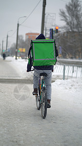 考勒在冬天送食物和背包男性午餐人行道盒子商业街道工作男生职业导游图片