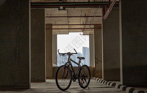 登山车停在空荡荡的停车场水泥阳光自行车冒险闲暇阴影山地建筑建筑学街道图片