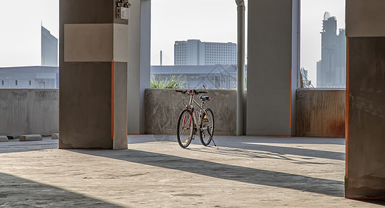 傍晚的光影穿过柱子和山地车日落建筑学自行车车道阳光停车场山地街道运输车轮图片