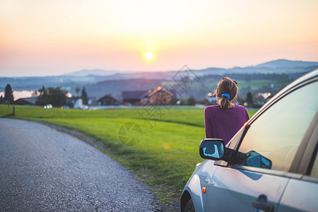 享受日落 路途之旅 年轻女孩正看着地平线女士后视镜旅行闲暇休息运输思维车辆天空自由背景图片