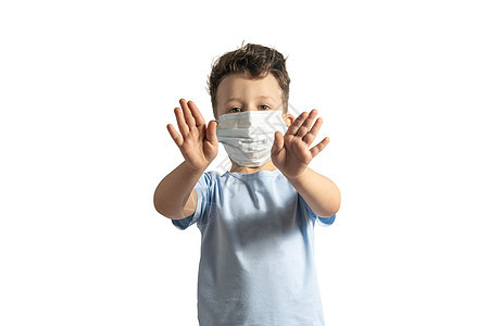 检疫的概念 儿童在流感病毒期间戴着医用防护面具 做出停止的手势 新冠肺炎 白人小男孩用手做停车牌 被白色隔离图片