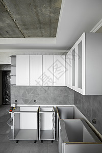 带有白色家具外墙 mdf 的定制厨柜安装 灰色模块化厨房由刨花板材料制成 处于不同的安装阶段 框架家具正面是 mdf 型材组装战背景图片