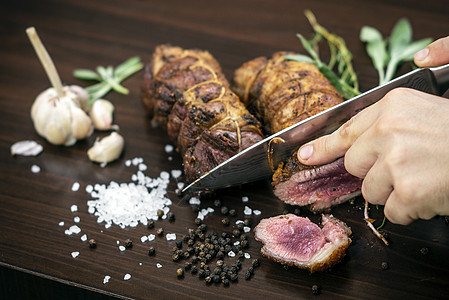 将有机烤牛肉卷切在配有成分的木制桌上桌子服务美食雕刻乡村拼盘木头食物男人木板图片