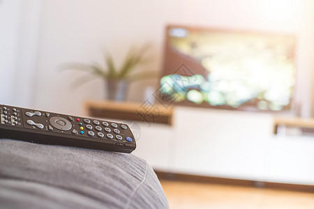 在沙发上的遥控器 流到智能电视上影院遥控娱乐渠道卫星电视节目屏幕展示按钮程序图片