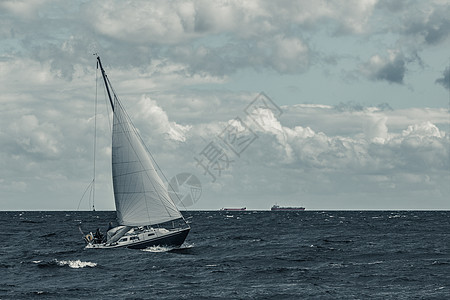 暴风时的蓝帆船桅杆运输蓝色乘客航行风暴运动调子船运游艇图片