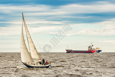 航行中的蓝帆帆船材料运动旅行船运游艇桅杆天空乘客水手运输图片