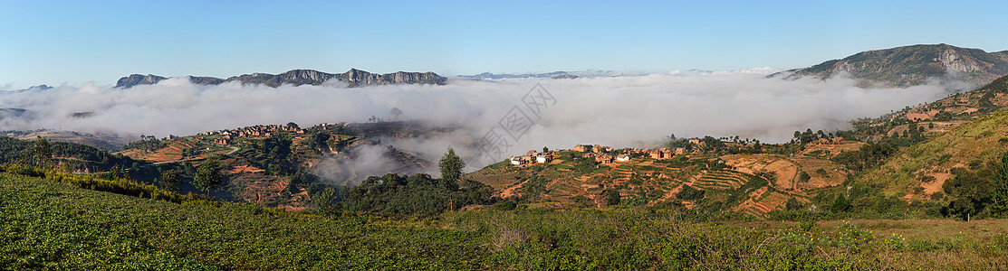 在马达加斯加附近地区的阳光明日早晨 与小村庄一起在山谷上空雾图片