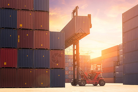 叉车在日出天空下在航运场或码头堆场起重货物集装箱 背景为货物集装箱堆 用于运输进出口和物流工业概念图片