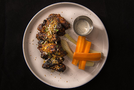 白盘上墨西哥风格的鸡翅盘子手指辣椒翅膀炙烤午餐食物水牛油炸胡椒图片