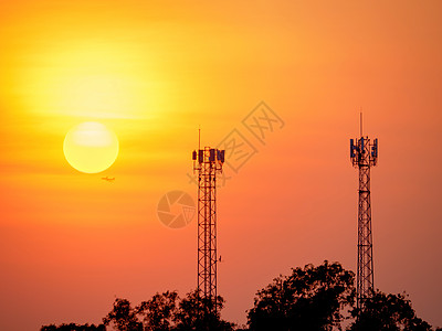 雷达信号塔以太阳照耀的暮光天空的周光轮廓发射通讯信号塔电视广播数据工程天线细胞频率技术橙子海浪背景