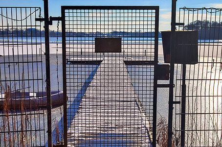 在德国阳光明媚的一天 雪在冰冻湖边覆盖了木制码头地平线天空旅行国家旅游新雪蓝色冰川假期风景图片