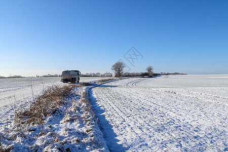 车 路在德国阳光明媚的一天 乡下公路被雪淹没公园全景沥青蓝色国家冻结旅行天空场景太阳背景