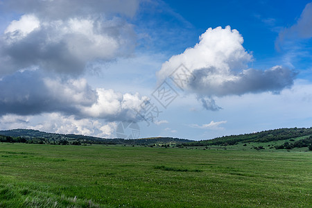 蓝天和白云下一片巨大的绿草地高清图片