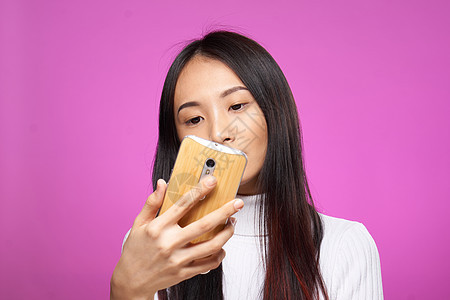 手持手机的漂亮女人 互联网技术信息 粉红色背景介绍学生乐趣微笑喜悦成功电话工作粉色女性广告图片